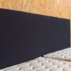 zwart bed hoofdbord met een houten achtergrond
