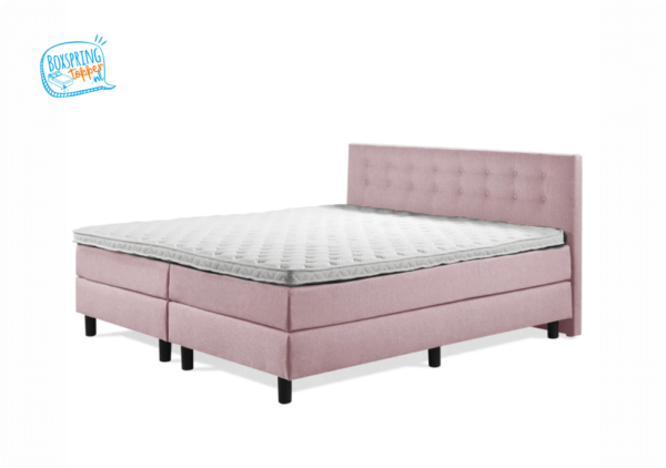 Roze bed met een knopen hoofdbord